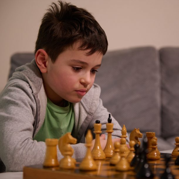 focused european boy playing chess HobSpace